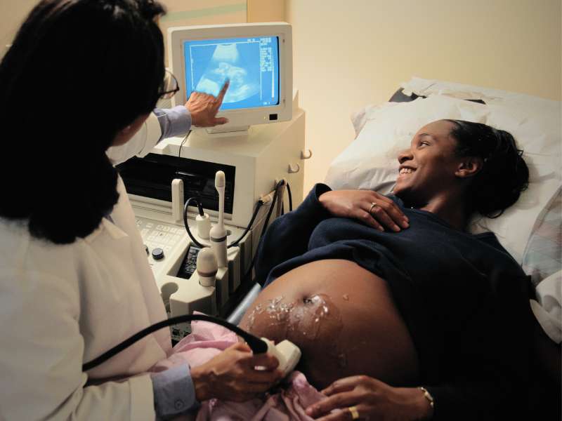 a healthcare worker conducts an ultrasound on a pregnant woman