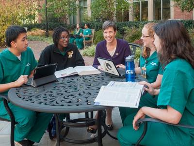 students share a table with Jean Giddens in the school's garden