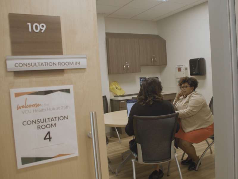 nursing student anna hembrick and dr. kimberly battle meet in a room of the health hub before greeting mobile health and wellness participants