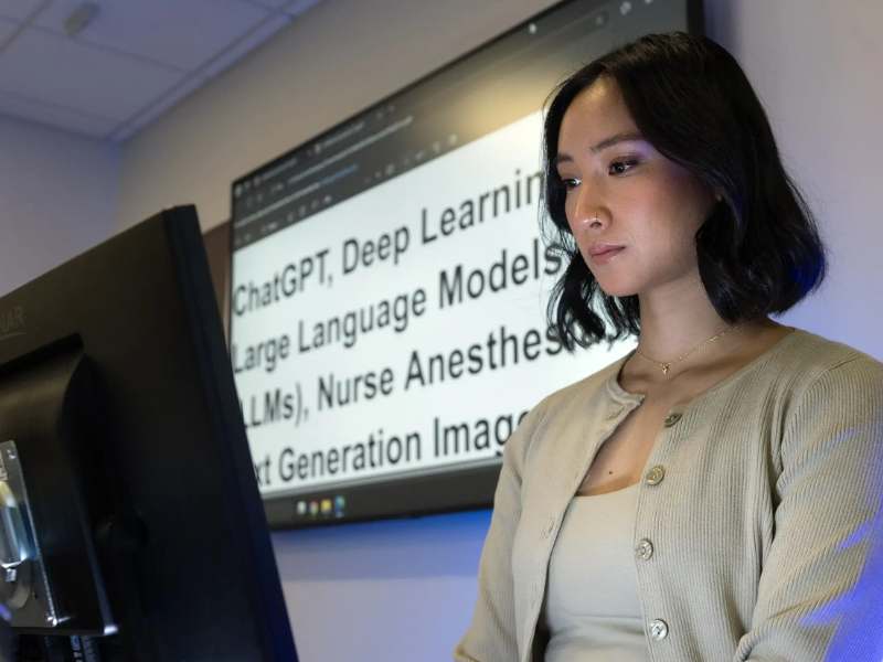 cayla ann deguzman stands over a computer monitor