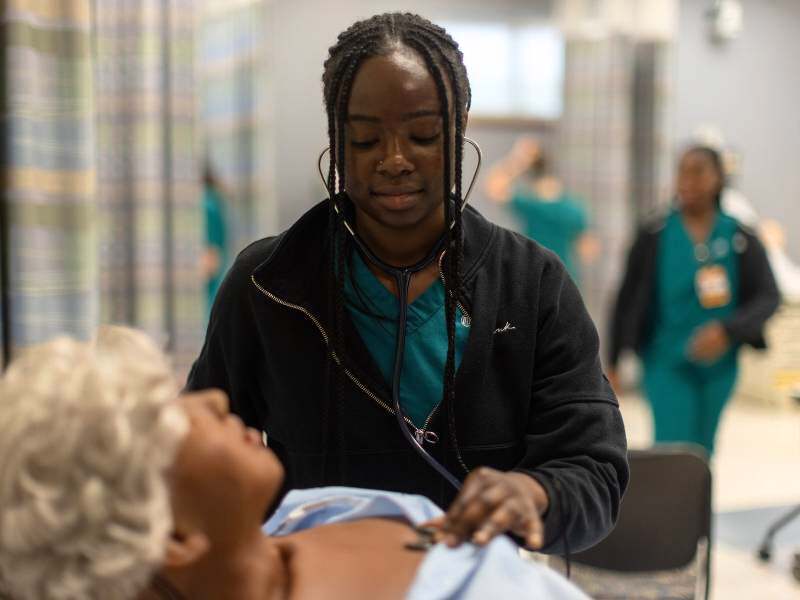 an undergraduate student works on a skill in the clinical learning center