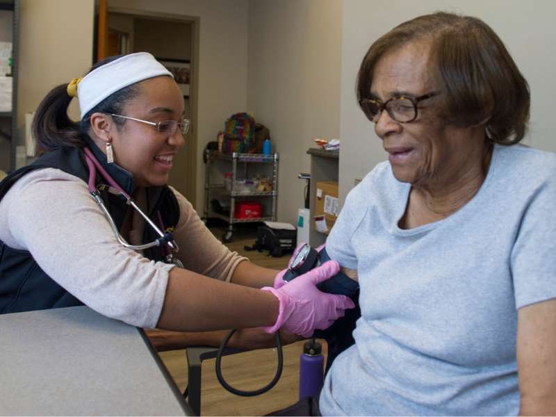 a nursing student performs a blood pressure check on a community clinic participant