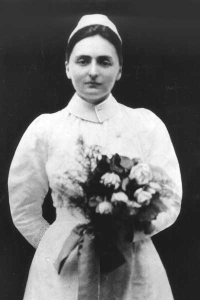 a uniformed nurse from the nineteen twenties era named sadie heath cabaniss holding a bouquet of flowers